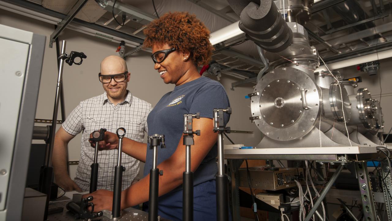 Ke'La Kimble, a chemistry major, works with associate professor Kyle Crabtree as he show her how laser mirrors are calibrated.