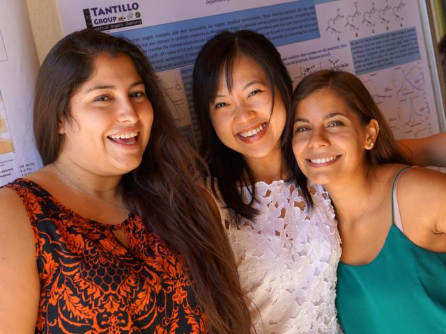 Three graduate students standing in front of a scientific poster. (PC: Minh Hoang)