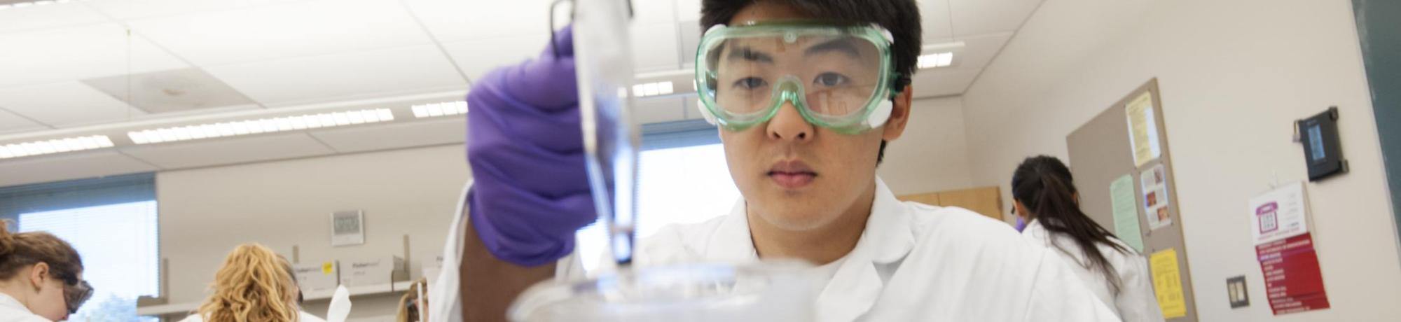 A biological sciences major at UC Davis, heats a beaker and checks the color for a chemical reaction during a Chemistry 2C lab at UC Davis on Tuesday, April 29, 2014.  The students were preforming qualitative analysis on a solution, trying to identify the five cations present.